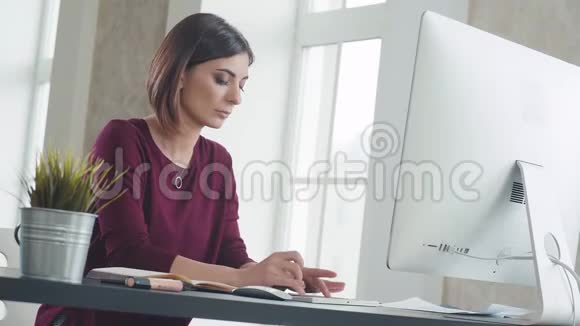 一个雄心勃勃的女人的工作场所她坐在电脑前视频的预览图
