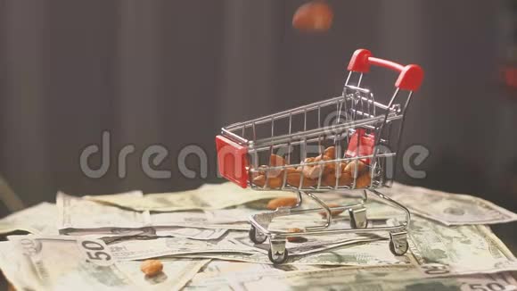 超市里装满杏仁坚果的购物车杏仁坚果掉在背景上的超市手推车里视频的预览图