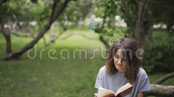 靠近一个在公园看书的女孩向下倾斜视频的预览图