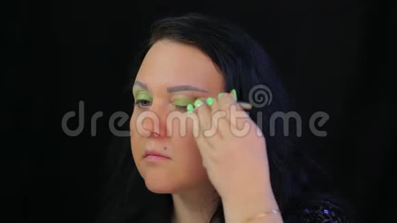 布鲁内特女士用绿色阴影做眼妆视频的预览图