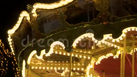 在狂欢节上老式旋转木马在美丽的旋转木马周围闪烁的灯光黑暗的夜空照明视频的预览图