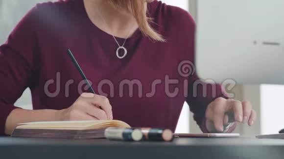 概念办公室工作一名年轻妇女在笔记本上工作并做笔记视频的预览图