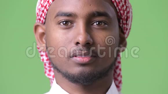 年轻英俊的非洲男子身穿传统穆斯林服装绿色背景视频的预览图