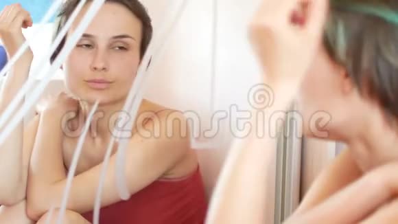 早晨一个女人看着镜子里的倒影视频的预览图