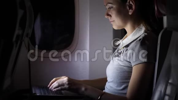 年轻女子晚上在飞机上工作视频的预览图