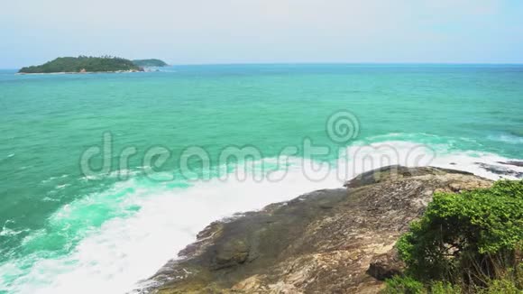 热带海洋的波浪在海滩上的岛屿岩石上裂开视频的预览图