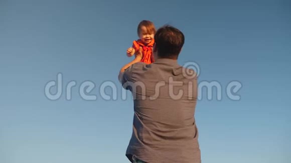 爸爸把女儿抛在蓝天上爸爸和一个小孩子玩幸福的家庭在晚上和视频的预览图