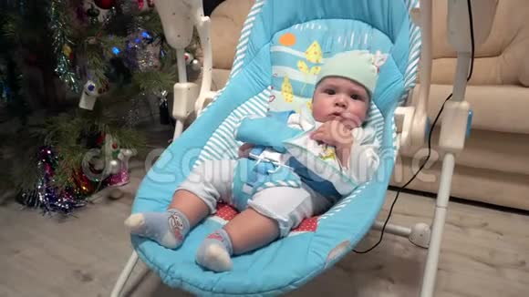 刚出生的男孩在电动婴儿椅上摇摆视频的预览图