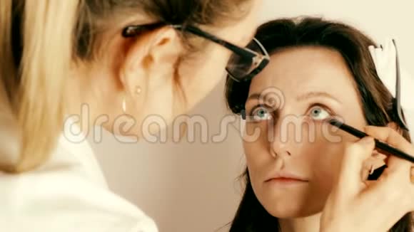 化妆师将化妆应用于成人模特面部视频的预览图
