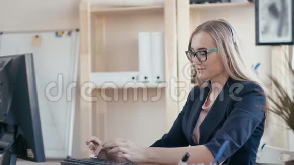 呼叫中心员工在办公室工作女孩打电话在键盘上打字看着视频的预览图
