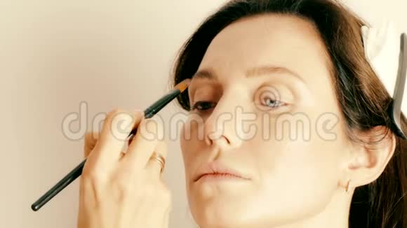 化妆师将安吉丽娜朱莉风格的化妆应用于模特的面部视频的预览图