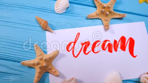 做梦的文字书法家用红墨水在白色画布上刻字激励词的字体贝壳和海星视频的预览图