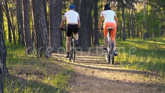 男人和女人骑自行车骑着森林小径视频的预览图