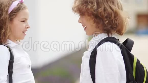 几个学童一个女孩和一个男孩学校的友谊孩子们穿着白色衬衫校服视频的预览图