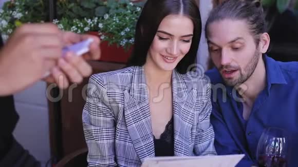 在餐厅的情侣在咖啡馆点菜单的人视频的预览图