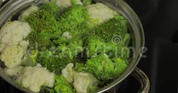 用沸水在锅里煮出五颜六色的西兰花和花椰菜视频的预览图