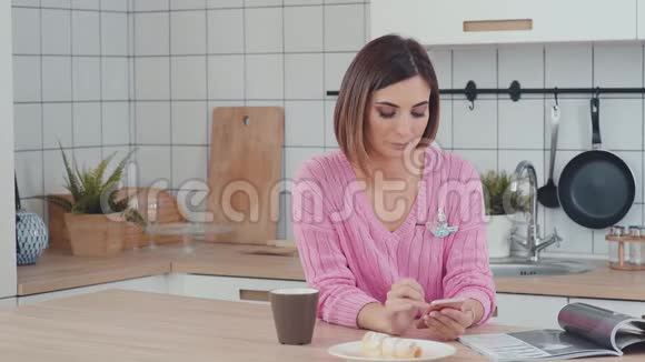 一个现代女人的早晨她正在吃早餐看新闻视频的预览图