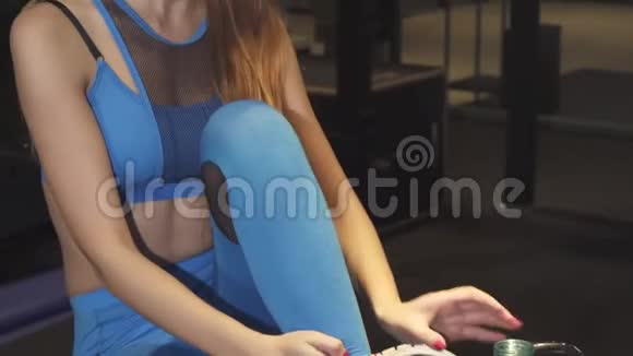 美丽快乐的健身妇女在健身房训练后微笑饮水视频的预览图