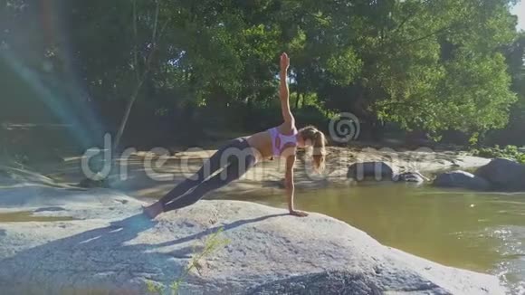 Flycam秀女孩手持瑜伽姿势对抗平静的河流视频的预览图