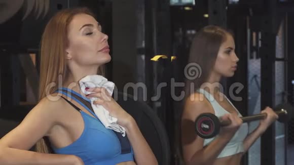 快乐的女运动员在健身后用毛巾擦脖子视频的预览图