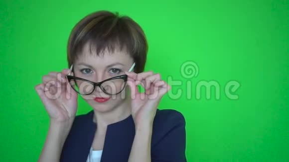 穿西装戴眼镜的女商人在绿色的屏幕背景上跳舞视频的预览图