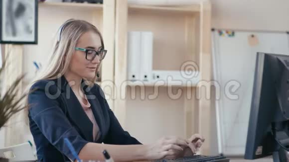 呼叫中心员工在办公室工作女孩打电话在键盘上打字看着视频的预览图