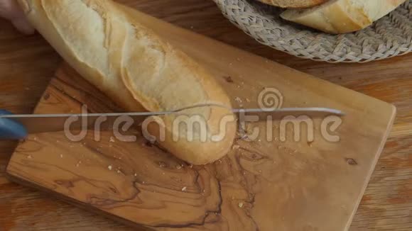 用刀在木切割板上切割法国面包视频的预览图