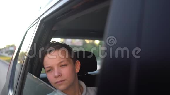 年轻英俊的青少年在阳光明媚的日子里和司机一起乘坐出租车旅行的肖像视频的预览图