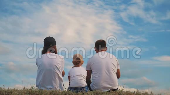 一家人在草地上举起双手做梦幸福的家庭观念生活方式自由视频的预览图