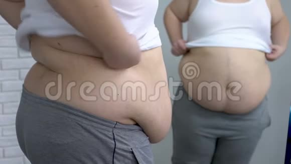 肥胖男性在镜子前穿上白衬衫渴望减肥视频的预览图