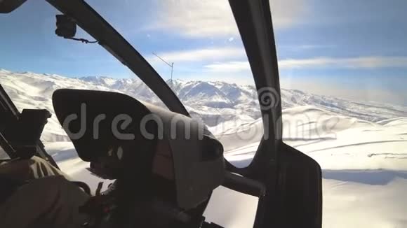 从直升机驾驶舱内空中俯瞰仪器面板飞越冬季山峰视频的预览图