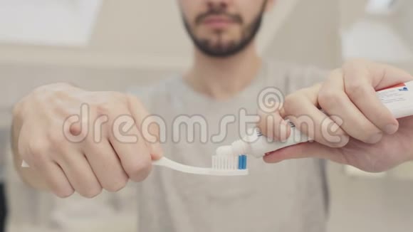 男人把牙膏挤在牙刷上视频的预览图