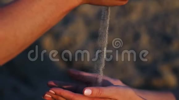 男人在夕阳下把沙子洒在女人手里视频的预览图
