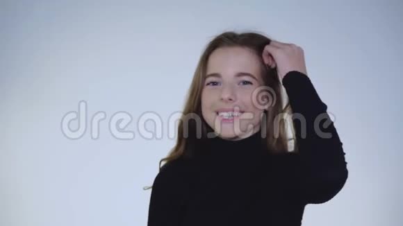 可爱谦虚的女孩在镜头前纠正头发和点头的肖像视频的预览图