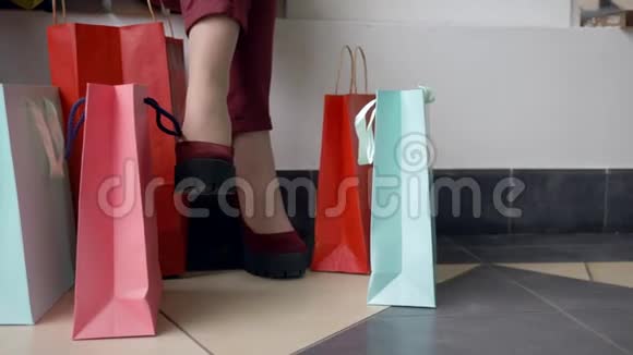 购物日时尚女孩的脚与许多彩色购物袋在折扣和销售季节视频的预览图
