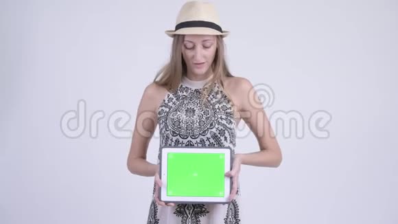 一位快乐的金发女游客展示数字平板电脑的画像视频的预览图