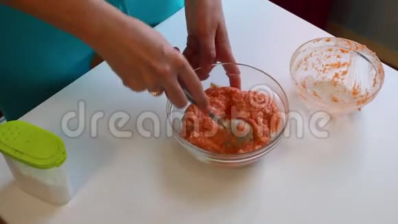 一个女人正在用鲑鱼做肉糜将切碎的鲑鱼肉与鸡蛋和碎面包混合在容器中视频的预览图