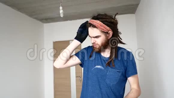 一个留着胡子的年轻人擦着额头上的汗维修概念视频的预览图