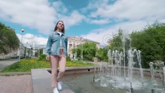 在喷泉附近的城市里美丽的女孩视频的预览图