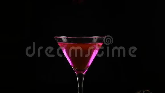 女人手在黑暗中准备一杯带樱桃的粉红色酒精鸡尾酒派对概念慢动作视频的预览图