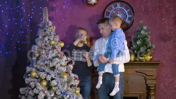 一位妇女在圣诞节庆祝活动中向儿子和丈夫展示了一个小包视频的预览图
