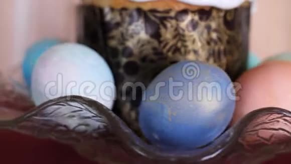 以彩色复活节彩蛋为装饰的传统复活节蛋糕在木制背景的漂亮玻璃板中旋转视频的预览图