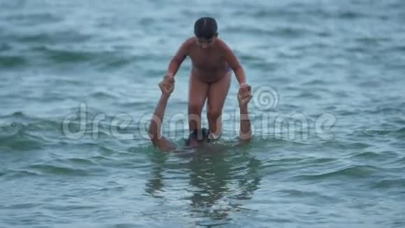 父亲和儿子在海里玩耍跳入水中慢速动作视频视频的预览图
