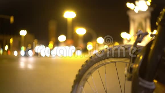 自行车轮特写散焦夜间交通延时城市交通视频的预览图