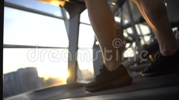 运动员腿在跑步机上行走下班后进行日落训练减轻压力视频的预览图