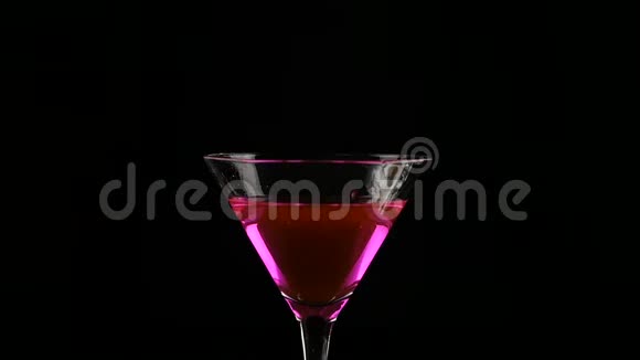 女人的手在黑暗中准备一杯带柠檬的粉红色鸡尾酒派对概念慢动作视频的预览图