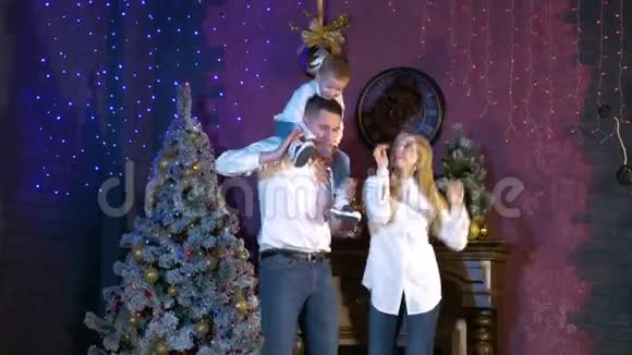 年轻夫妇和他们的孩子在圣诞节做庆祝舞会视频的预览图