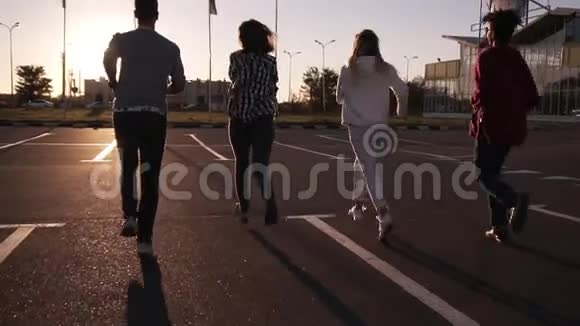 四位朋友正在户外的空停车场附近跑步快乐年轻的男女正在跑步视频的预览图