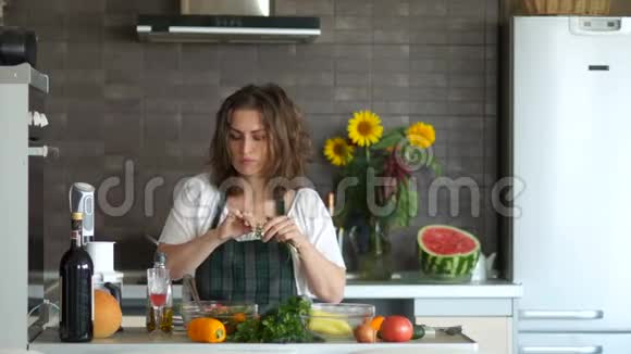 年轻的女人拿着刀在厨房跳舞准备沙拉好心情母亲节视频的预览图