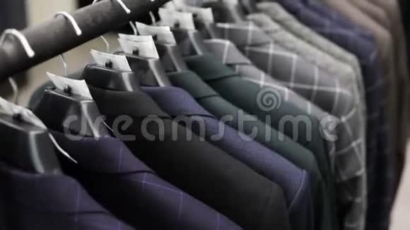 衣架与男士不同颜色的衣服背景的西装店特写视频的预览图